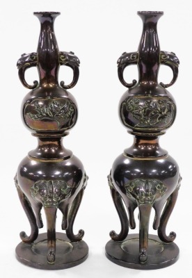 A pair of Japanese bronze vases, of twin handled baluster form, decorated in bas relief with panels of birds and dragonflies, raised on three lion's head capped cabriole legs, 21cm high. - 5