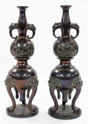 A pair of Japanese bronze vases, of twin handled baluster form, decorated in bas relief with panels of birds and dragonflies, raised on three lion's head capped cabriole legs, 21cm high. - 6