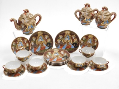 A Taisho period Japanese Kutani porcelain tea set, decorated with dragons in relief and reserves of figures, coral, red and blue decoration on a brown ground, with gilt highlights, comprising, teapot, two handled sucrier, creamer, six cups with geisha lit - 8