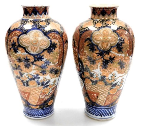 A pair of 19th/early 20thC Japanese Imari vases, of baluster form, decorated with reserves of flowering branches in coloured enamels, with gilt highlights, unmarked, 38cm high. (AF)