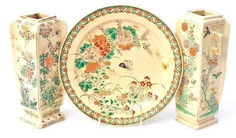 A pair of Meiji period Japanese Satsuma vases, each of square form with two handles, decorated with flowers and birds, beetles and a stork against a cream ground, unmarked, 22cm high, together with a similar dish, with impressed Taizan mark, 23cm diameter