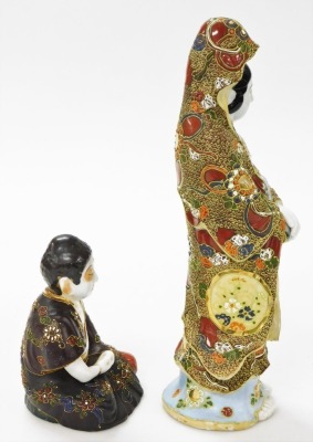 A Japanese Satsuma figure of Kannon, modelled standing holding a scroll, 34cm high, and a further Satsuma figure of a seated Buddha, 14cm high. (2) - 4