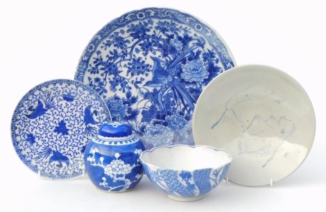 A group of blue and white Oriental ceramics, to include a transfer printed dish decorated with two birds amongst flowering branches, 31cm diameter, ginger jar and cover decorated with prunus blossom against a cracked ice ground, 12cm high, etc.