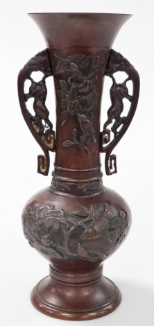 A Meiji period Japanese bronze vase, of twin handled baluster form, bas relief decorated with birds and flowers, 31cm high.