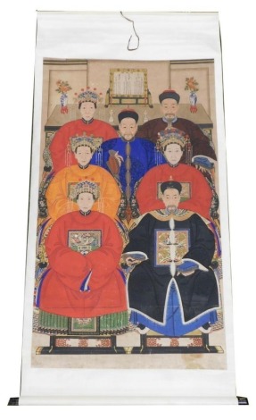 A Chinese ceremonial ancestor portrait scroll, depicting seven family members in front of an altar table bearing a table screen, candlesticks and vases, watercolour on silk, 212cm x 104cm.