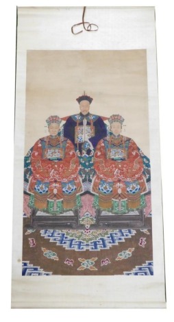 A Chinese ceremonial ancestor portrait scroll, depicting a high ranking court official with two of his wives, all seated in front of an elaborate carpet, watercolour on silk, 180cm x 86cm.