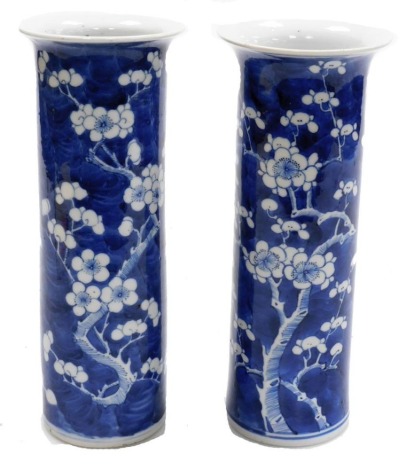 A pair of 19thC Chinese vases, each of cylindrical elongated form with flared neck, decorated with flowering prunus blossom on a cracked ice ground, blue four character Kangxi mark to underside, 25.5cm high.