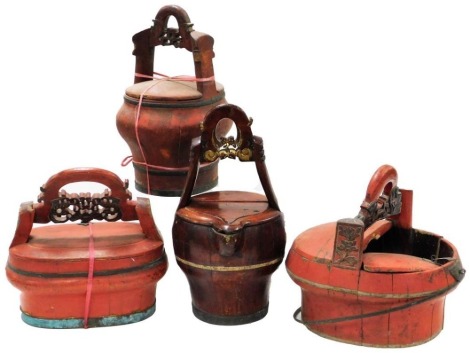 Four Chinese red lacquer wedding baskets, three with carved carrying handles, the other of twin open handled form, with lids.