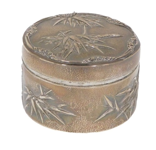 An early 20thC Wang Hing Chinese white metal powder box, repousse decorated with trees, on a hammered ground, marked beneath, 9cm diameter, 6oz, with 23 Hollywood Road, Hong Kong, Honey Church International Antiques Limited typed card.