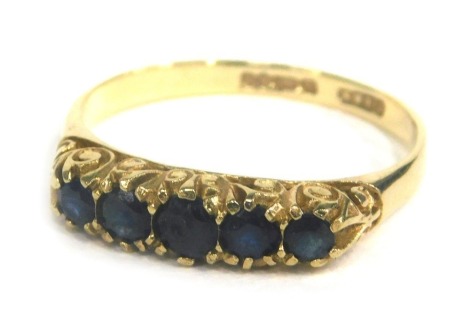 A 9ct gold dress ring, set with an arrangement of five graduated blue stones, size T, 2.5g all in, boxed.