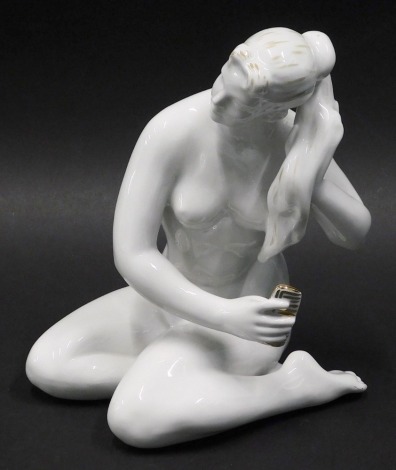 A Dulevo factory figure of a nude girl seated combing her hair, marked beneath, 19cm high.