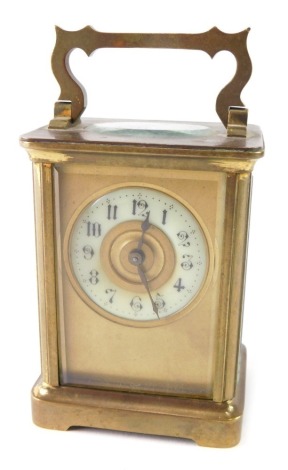 A small brass carriage or travel clock, with 5cm diameter Arabic dial, single barrel movement, on bracket feet, with swing handle, 11cm high.