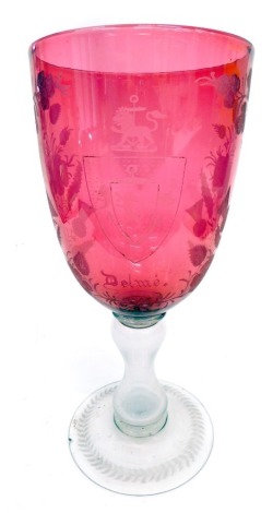 A 19thC enlarged cranberry etched and clear glass goblet, the bell shaped bowl with a lion shield crest marked DELME, with further roses, thistles and shamrocks, etc., on an hourglass stem and circular foot, unmarked, 43cm high. (AF)