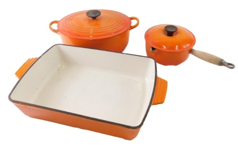 Various Le Creuset kitchen items, serving dish, 44cm wide, lidded pan, and lidded dish, in orange. (3)