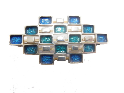 A David Anderson Norwegian brooch, of Art Deco design set with small enamel finish sections in blue and green broken by plain sections, with a plain pin back, mark D-A Norway 925 UNI Sterling, 6cm wide.