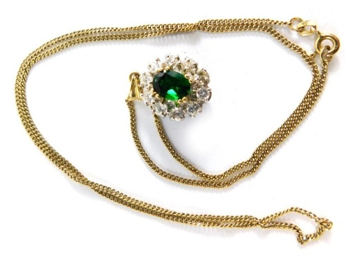 An emerald and CZ pendant, the pendant set with central oval heat treated emerald, 8mm x 5.8mm x 3.8mm, surrounded by eight round brilliant cut cz stones in claw platinum setting, unmarked on a gold fine link neck chain, the pendant 2.5cm high, the chain