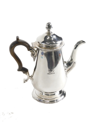 A George IV silver coffee pot, by Michael Starkey, with thumb mould wooden handle, domed lid, acorn finial, acanthus capped spout, tapering body etched with lion crest, on circular foot, London 1832, 24cm high, 16.9oz all in.