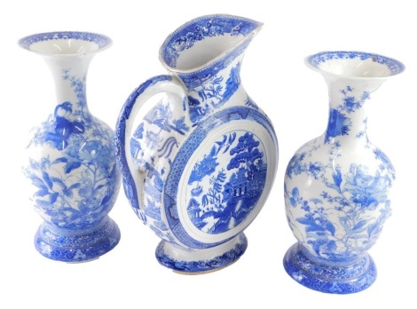 A pair of Japanese blue and white porcelain vases, each decorated with birds and flowers, and a large Willow pattern pottery transfer printed ewer, raised diamond registration mark beneath, 36cm high.