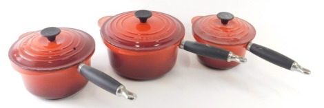 A graduated set of three Le Creuset saucepans, in red, 15cm high, etc. (3)