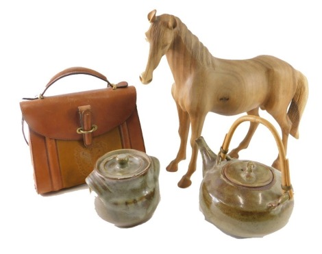 A heavily carved wooden figure of a standing horse, 43cm high, a leather evening bag with fleur de lys stamped decoration, a studio pottery kettle and lidded pot, indistinctly marked. (a quantity)