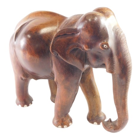 A large heavily carved wooden figure of an elephant, 45cm high.