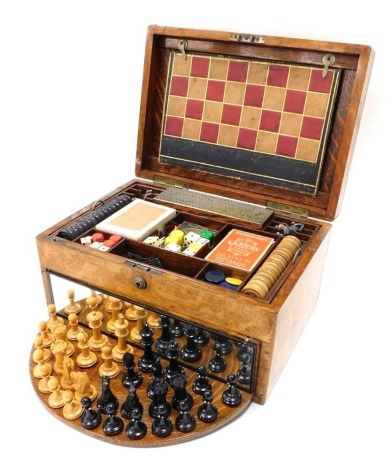 A 19thC oak games compendium, of rectangular form with vacant metal shield cartouche, the fitted interior with various games, chequer board, draughts, chess set, cards, with lift out section and further games beneath, 20cm high, 35cm wide, 23cm deep.