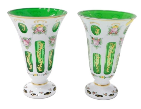 A pair of Bohemian green and milk glass overlaid vases, each decorated with garlands of flowers, 25cm high. (2, AF)