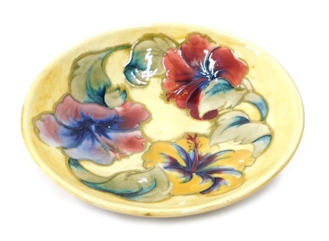 A Moorcroft Hibiscus pattern bowl, on yellow ground, labelled beneath, 17cm diameter.