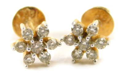 A pair of tiny diamond set cluster earrings, set in yellow metal.