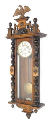 A late 19thC Gustav Becker walnut cased double weight Vienna clock, of large proportion, with eagle finial, raised above 18cm diameter Roman numeric dial, with subsidiary Arabic second hand, flanked by quarter columns, with pendulum and two weights, 114cm