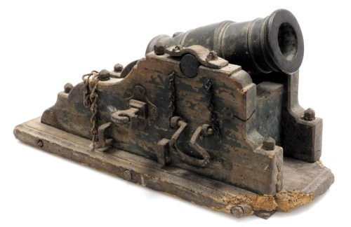 A 19thC Continental bronze mortar cannon, sitting within a painted wooden and cast iron carriage, 43cm wide.