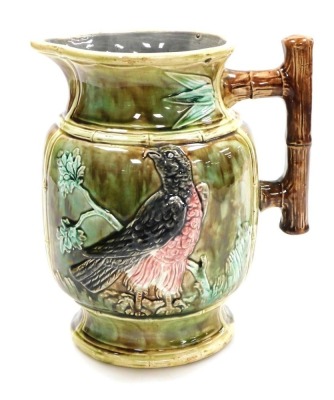 A late 19thC Continental Majolica jug, with a bamboo style handle, moulded with birds and oak branches, 23.5cm high.