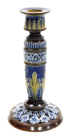 A late 19thC Doulton Lambeth stoneware candlestick, moulded with repeating bands of leaves and flowers, impressed and incised marks, 20.5cm high.