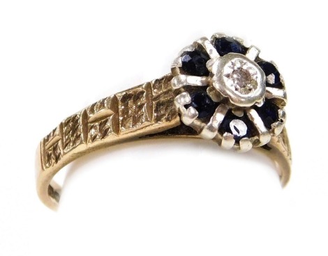 A 9ct gold sapphire and diamond flower head ring, in a basket setting, with engraved shoulders, size M, 3.1g.