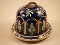 A Victorian Majolica cheese dish and cover decorated with leaves and flowers