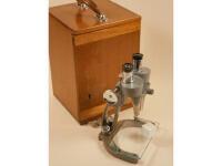 A cast steel microscope in a mahogany case