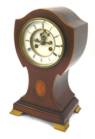 An Edwardian mahogany and inlaid mantel clock, of shaped balloon form, enamel Roman numeric dial, eight day movement, on four brass bracket feet, 35cm high.