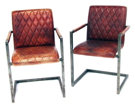 A pair of Scandinavian metal framed armchairs, with quilted tan PVC seats and back rests, 85cm high. The upholstery in this lot does not comply with the 1988 (Fire & Fire Furnishing) Regulations, unless sold to a known exporter or upholsterer it will be c