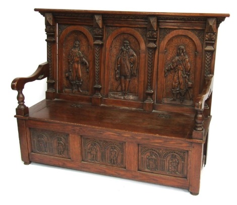 An oak settle in 17thC style, the carved back depicting three cavaliers, supported by four carved turned tapering columns, the base with blanket chest section above three carved panels depicting six figures, with carved floral side panels, on stiles, 126c