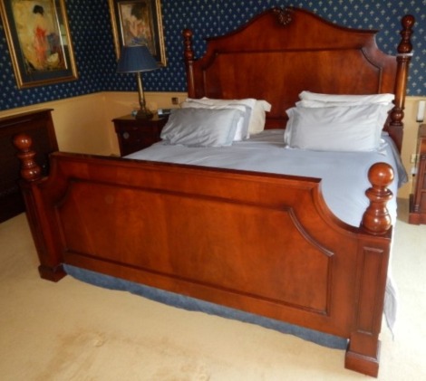 A mahogany Emperor bed, with a shaped head and foot, the head surmounted by a carved shell, raised on four column supports with turned finials, on stepped square feet, 217cm wide. See Lots 815, 835 and 836 for complimentary bedroom furniture from the same