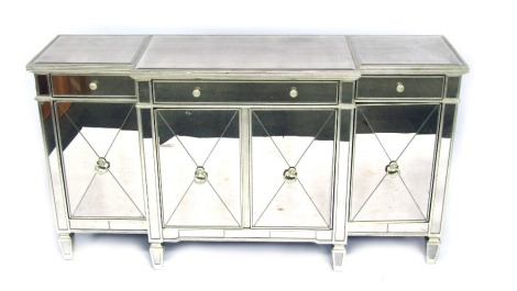 A 20thC mirrored breakfront sideboard, the top with a moulded edge, above one long and two adjacent smaller drawers, above four hinged doors with loop handles, raised on spade feet, 97cm high, 176cm wide, 51cm deep.