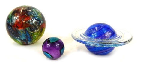 Two Glass Eye Studio paperweights, comprising Rings of Saturn, and another of floral swirl and bubble decoration, with gold highlights, boxed, and a marble. (3)