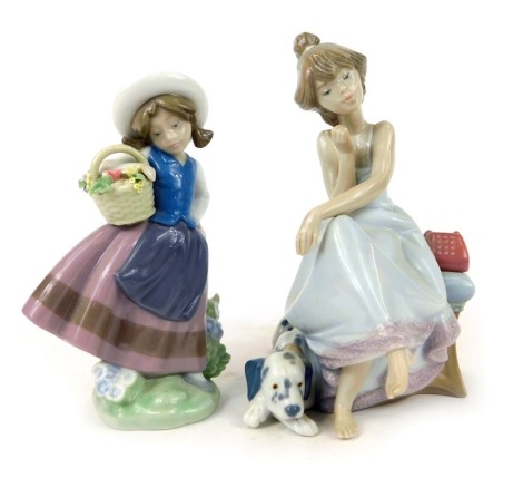 Two Lladro figures, comprising girl carrying basket of flowers, 17cm high, and a lady on a telephone seat with dog, 20cm high. (2)