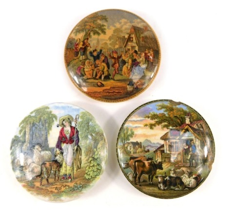 Three 19thC Prattware style pot lids, comprising Castle Hut, 10cm diameter, The Village Wedding, and a transfer printed later example with sheep and shepherdess. (3, AF)