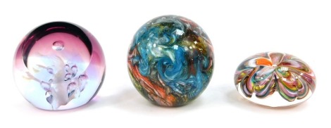 Three glass paperweights, comprising a 2016 Isle of Wight mottled glass dump, Caithness Moon Orchid 371/1000, and Isle of Wight studio glass flower weight. (3)