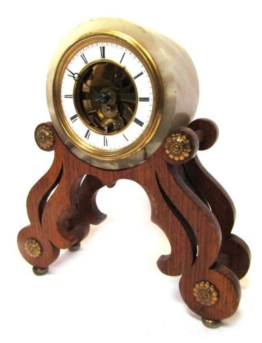 A French mantel clock, with a circular white onyx frame, with central open work skeleton movement, with a white enamel Roman numeric chapter ring, on an oak shaped base, the movement stamped Chappement Brevete and numbered 45744, 23cm high, 21cm wide.