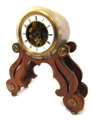 A French mantel clock, with a circular white onyx frame, with central open work skeleton movement, with a white enamel Roman numeric chapter ring, on an oak shaped base, the movement stamped Chappement Brevete and numbered 45744, 23cm high, 21cm wide.