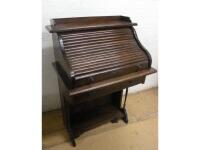 An early 20thC oak roll top desk with a tambour front enclosing a fitted