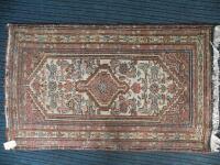 A Persian rug with a central medallion on a cream ground