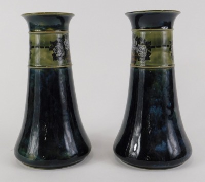 A pair of Royal Doulton stoneware vases, each decorated with a band of roses within buckets, above a mottled blue band, impressed marks to underside and indistinct makers monogram, 21cm high. - 2